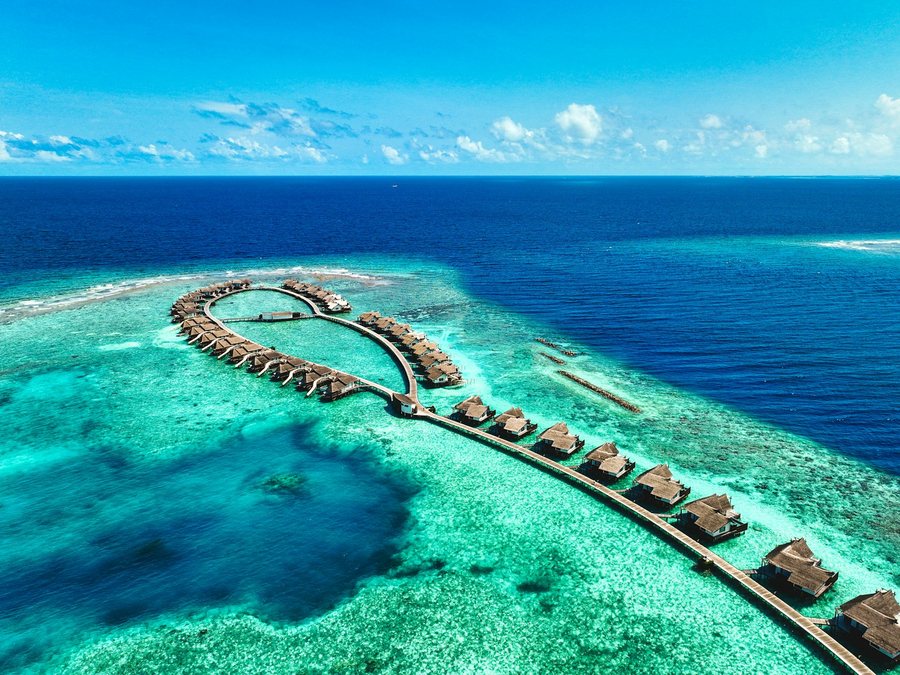 Overwater villas curving across a turquoise lagoon